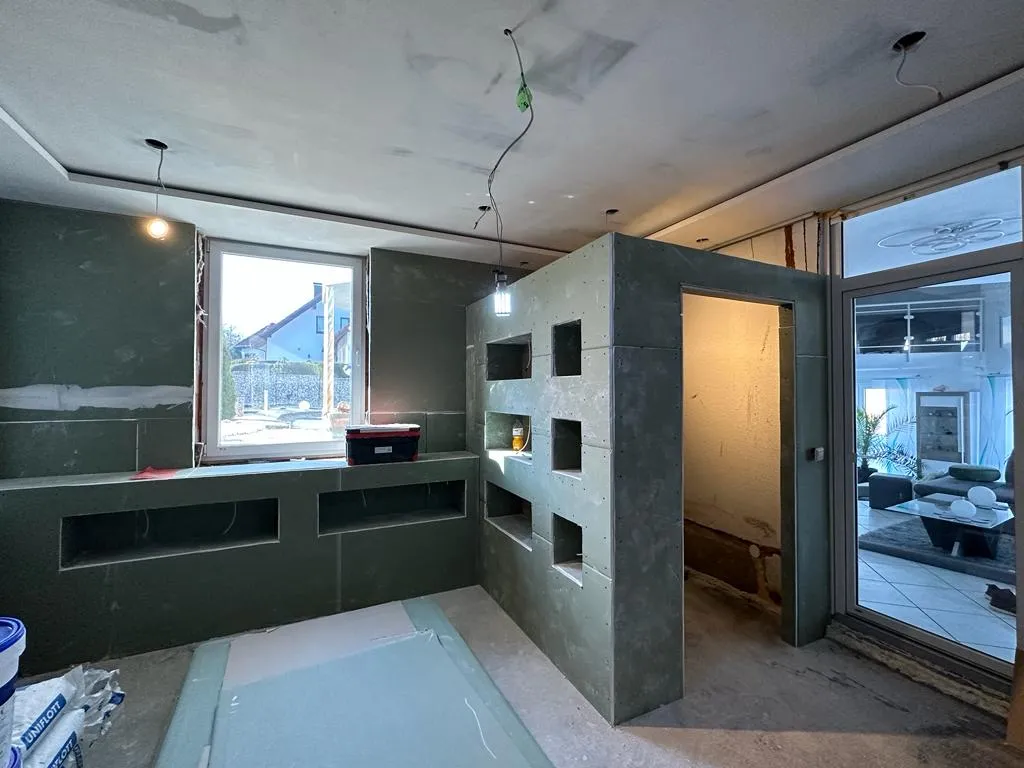 Badausbau mit grünen Imprägnierplatten und vorbereiteten Sanitär-Nischen